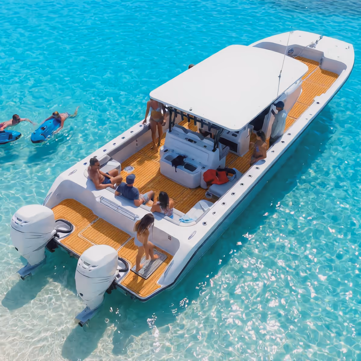 Friends swimming off a boat in turquoise water